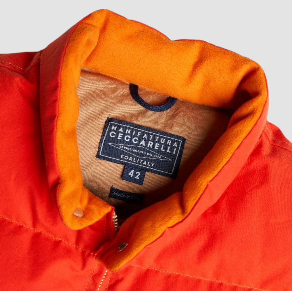 Orange goose down vest with water-repellent dry cotton shell, 90/10 white goose down fill, zip closure, snap button collar, and leather details.