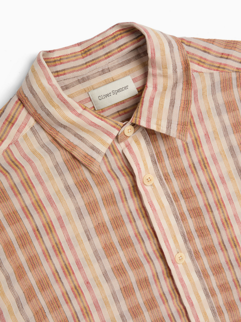 Multi-colored oversized long-sleeve shirt in lightweight cotton-linen seersucker, featuring a spear collar, front patch pocket, curved hem, and contrast gusset.