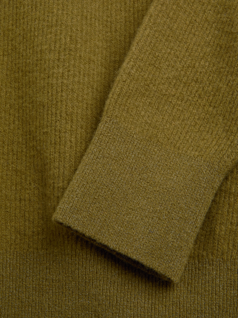Close-up of a green sweater sleeve.