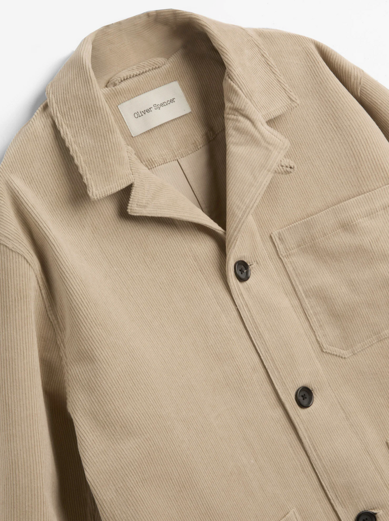 Beige corduroy jacket with a brand label on a light gray background.