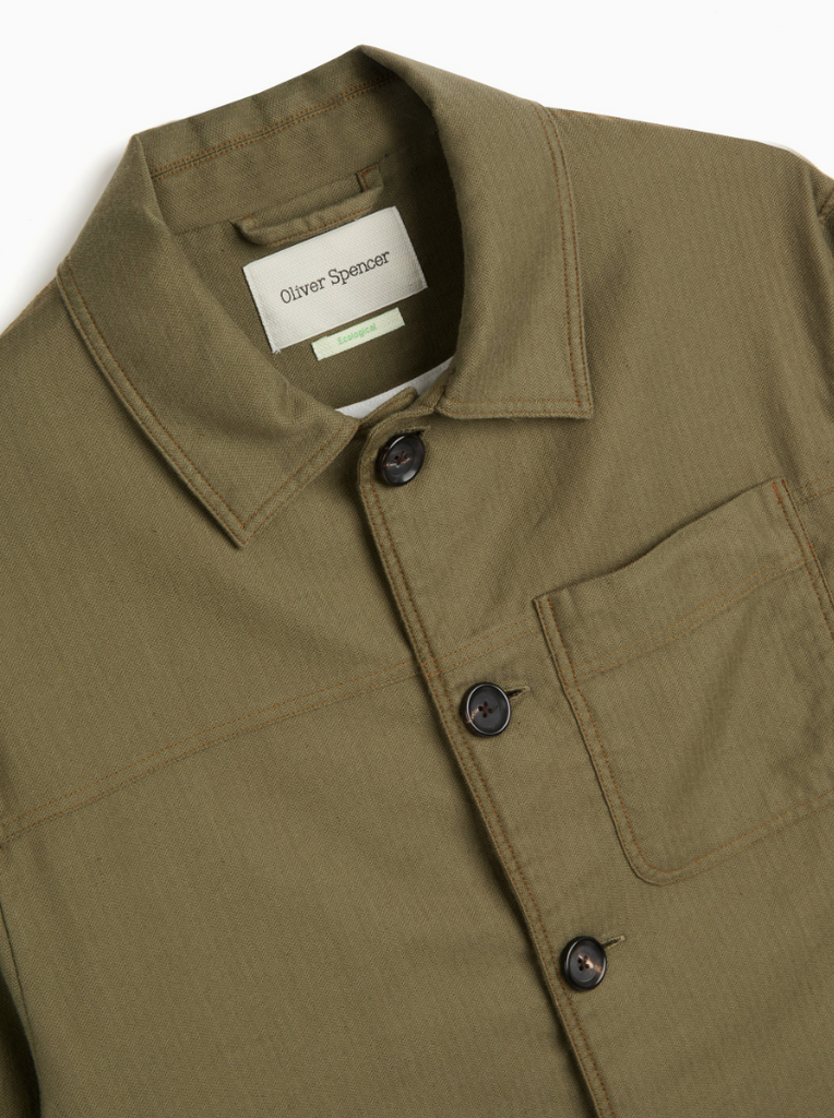 A green trucker jacket in a linen-cotton herringbone blend, featuring button fastening, welted pockets, and a chest patch pocket for a classic look.