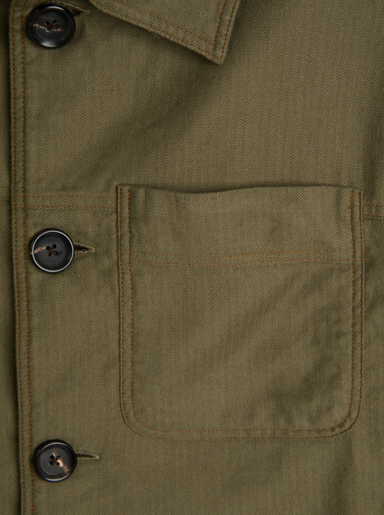 A green trucker jacket in a linen-cotton herringbone blend, featuring button fastening, welted pockets, and a chest patch pocket for a classic look.