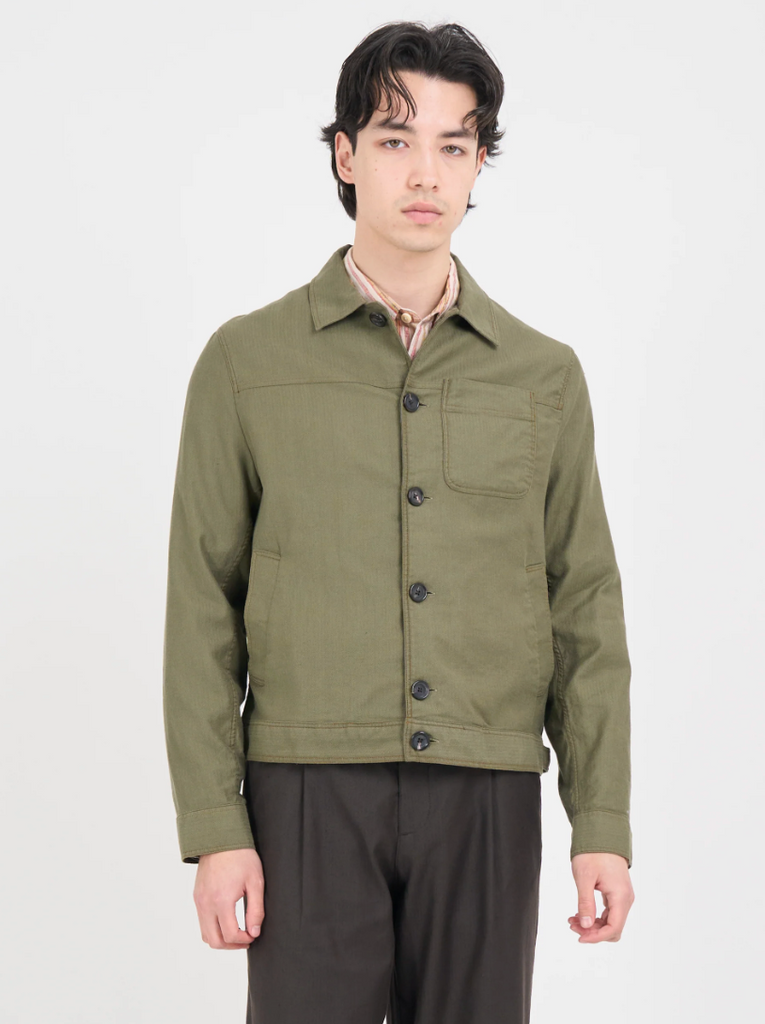 A green trucker jacket in a linen-cotton herringbone blend, featuring button fastening, welted pockets, and a chest patch pocket for a classic look.