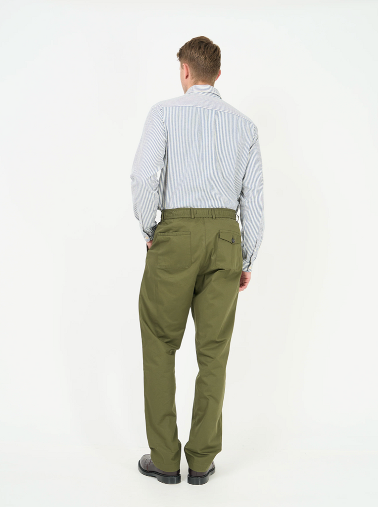 Man wearing green pants and a light blue shirt on a white background.