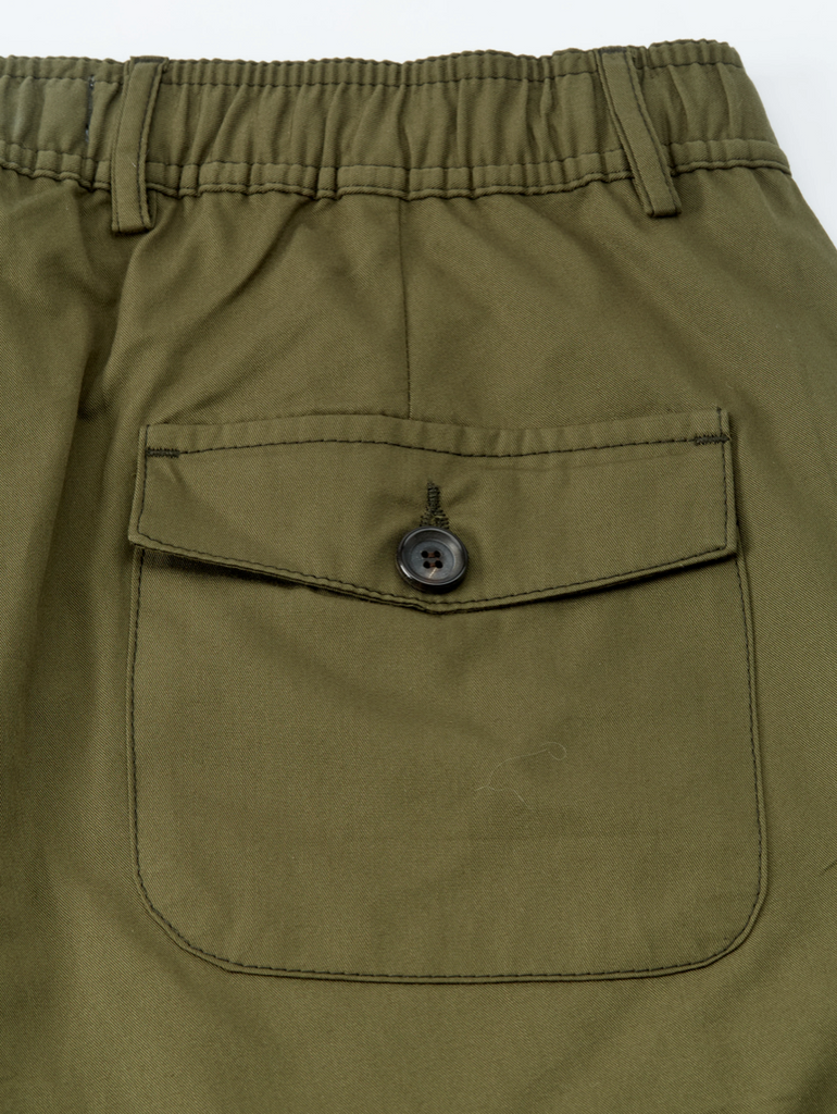 Close-up of olive green pants with a pocket and button on a white background.
