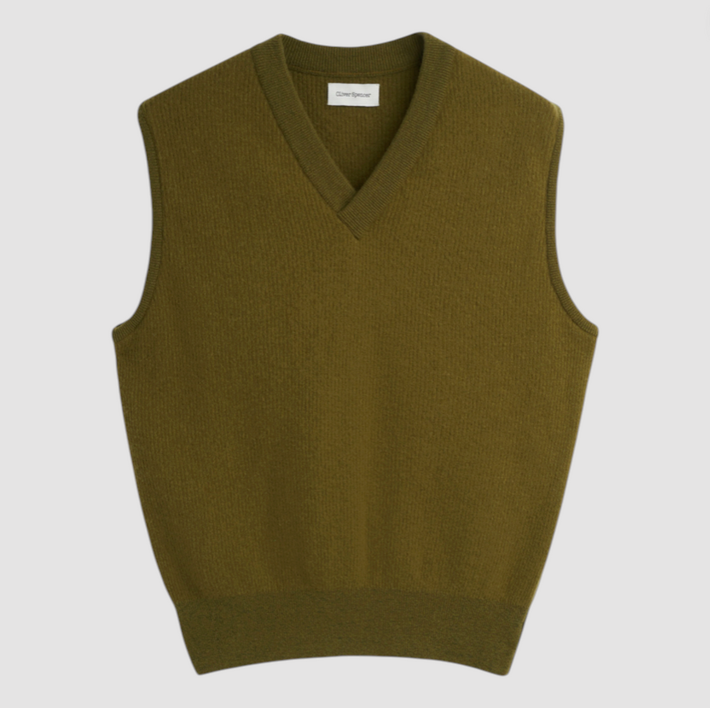 Green sweater vest on a light gray background.