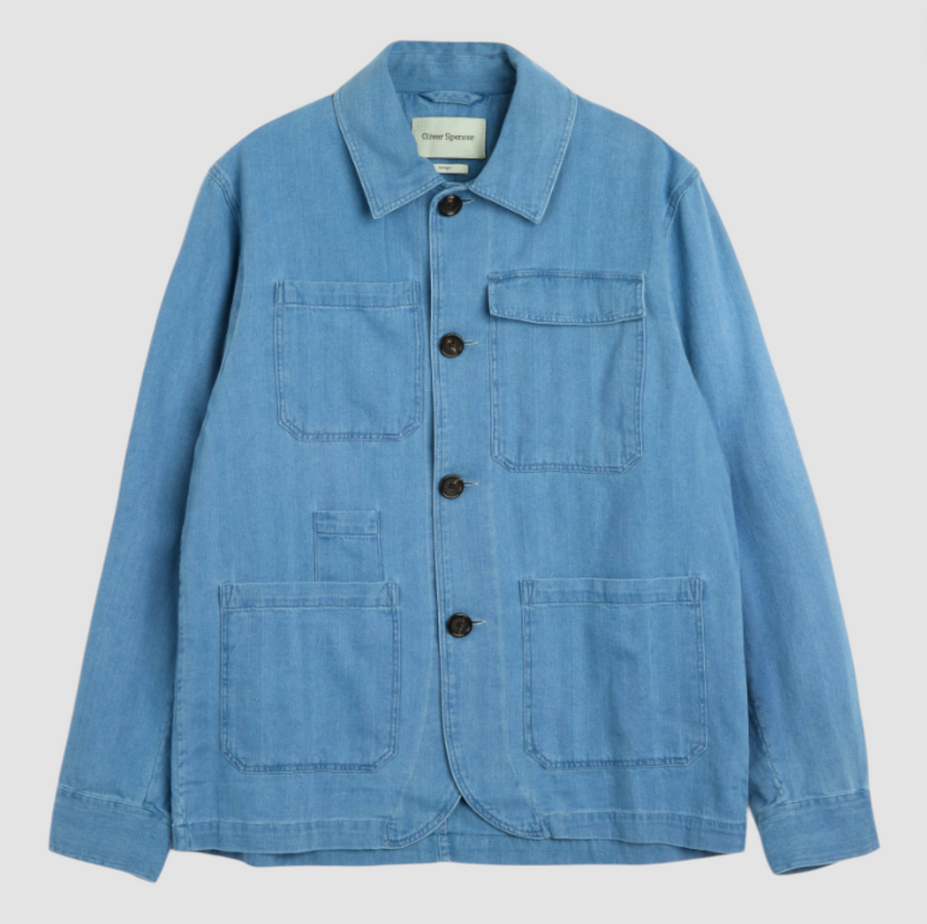 A bleach-washed indigo chore jacket with a herringbone weave, featuring multiple patch pockets and corozo button details.