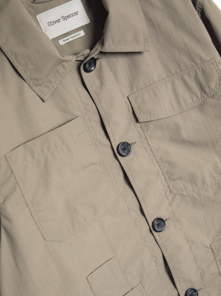 Khaki regular-fit chore jacket made from lightweight, water-repellent recycled polyamide, featuring multiple patch pockets and horn button closures.