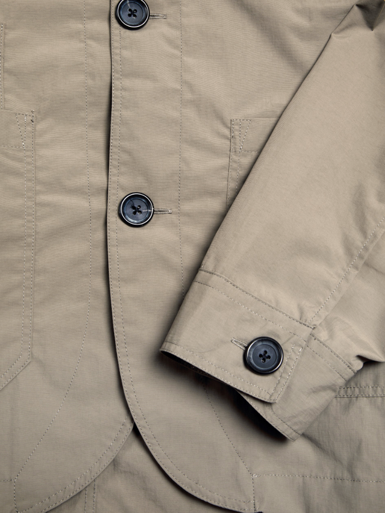 Khaki regular-fit chore jacket made from lightweight, water-repellent recycled polyamide, featuring multiple patch pockets and horn button closures.