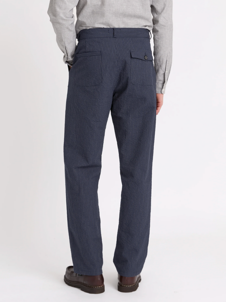 A pair of navy pleated trousers with a straight-leg cut, crafted from soft stretch cotton denim with front and rear pockets.