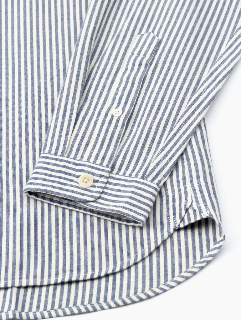 Close-up of a blue and white striped shirt  on a light background.