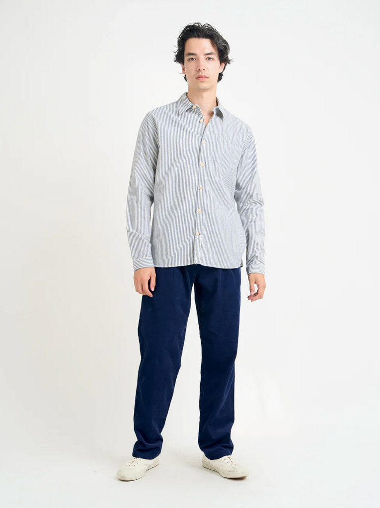 Person wearing a white and blue striped shirt and dark blue pants on a white background.