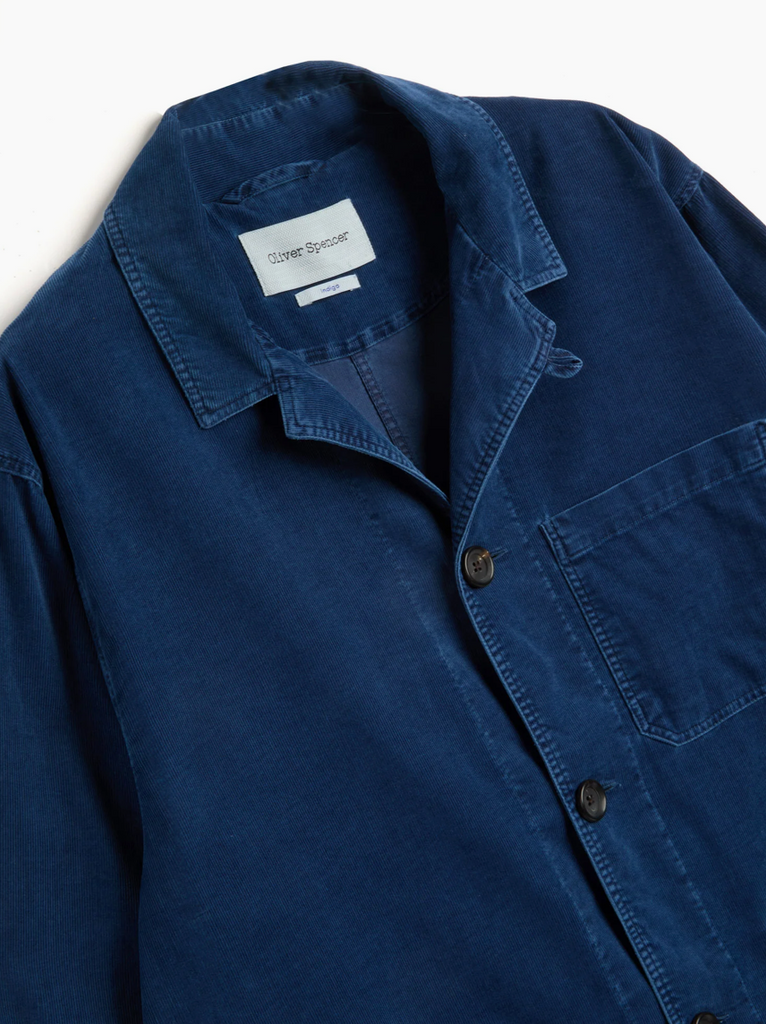 Blue corduroy jacket with a brand label on a white background.