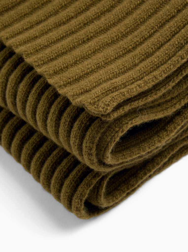 Folded ribbed green scarf on a white background.