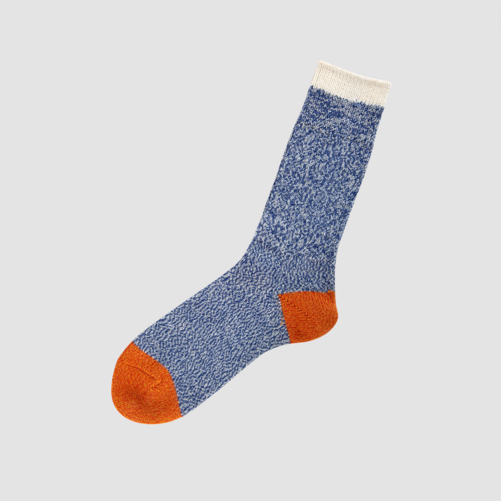 A pair of melange alpaca wool socks in azul and orange, featuring contrast details on the ankle and toe.