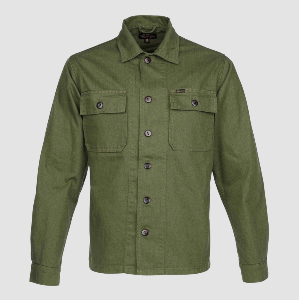Green shirt with button details on a light gray background.