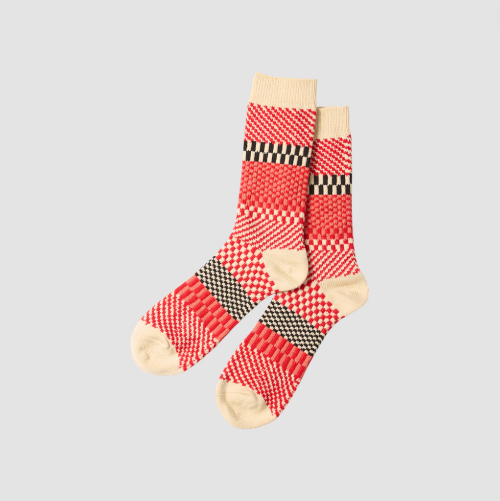 Red and ecru checkered socks on a light grey background.