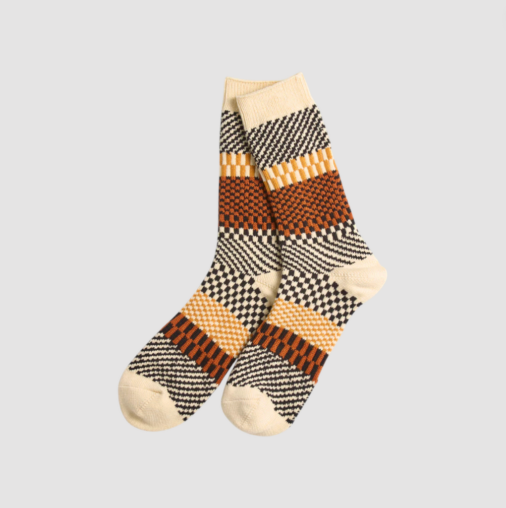 Pair of orange patterned socks on a light gray background.