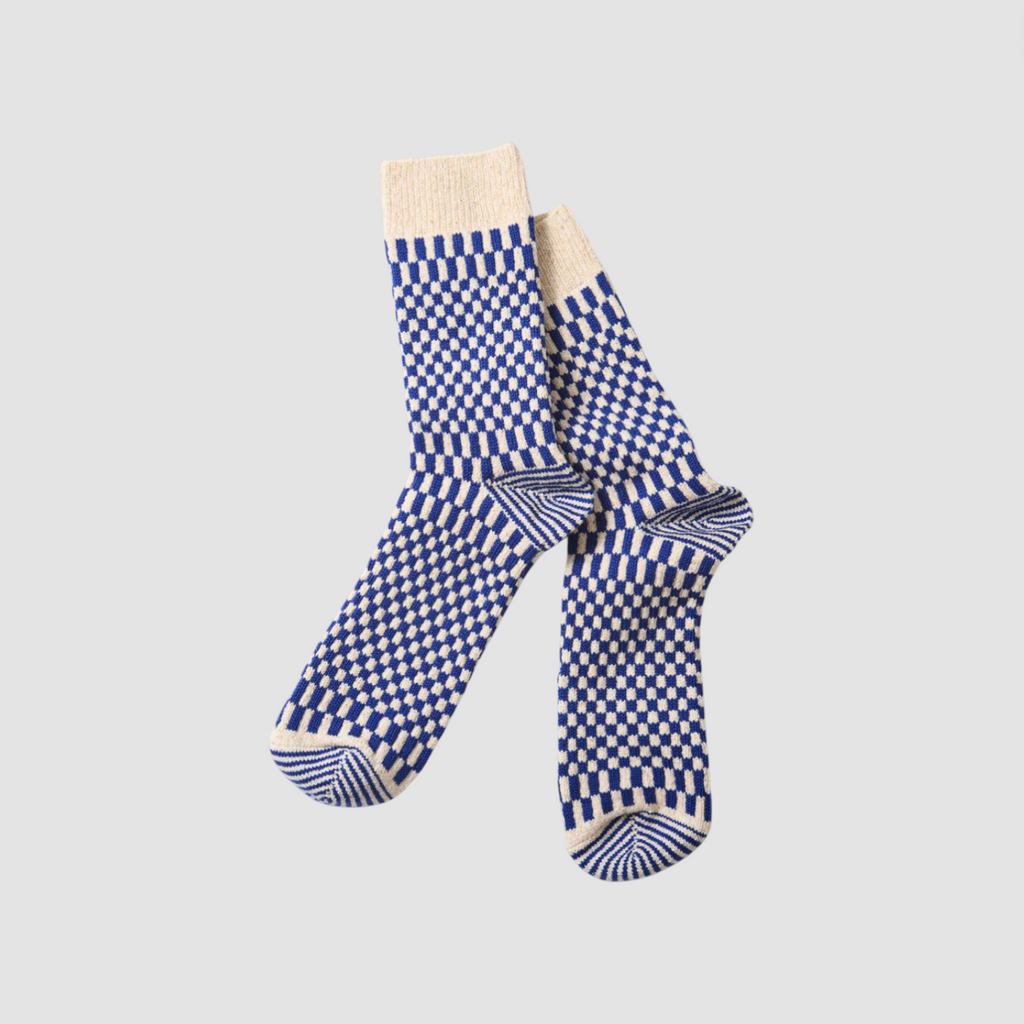 Pair of blue and white checkered socks on a light gray background.