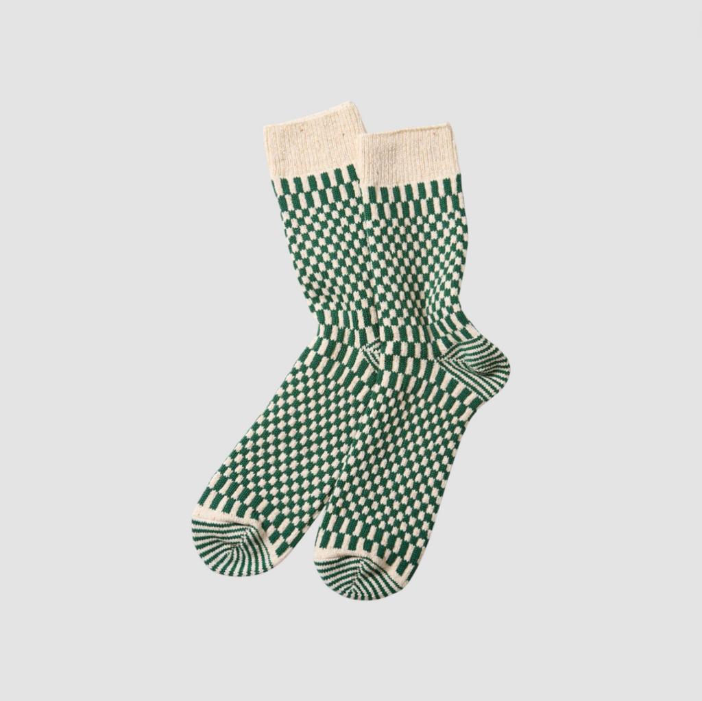 Green and white checkered socks on a light gray background.