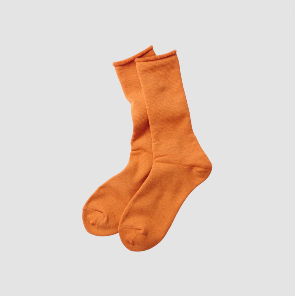 Pair of orange socks on a light gray background.