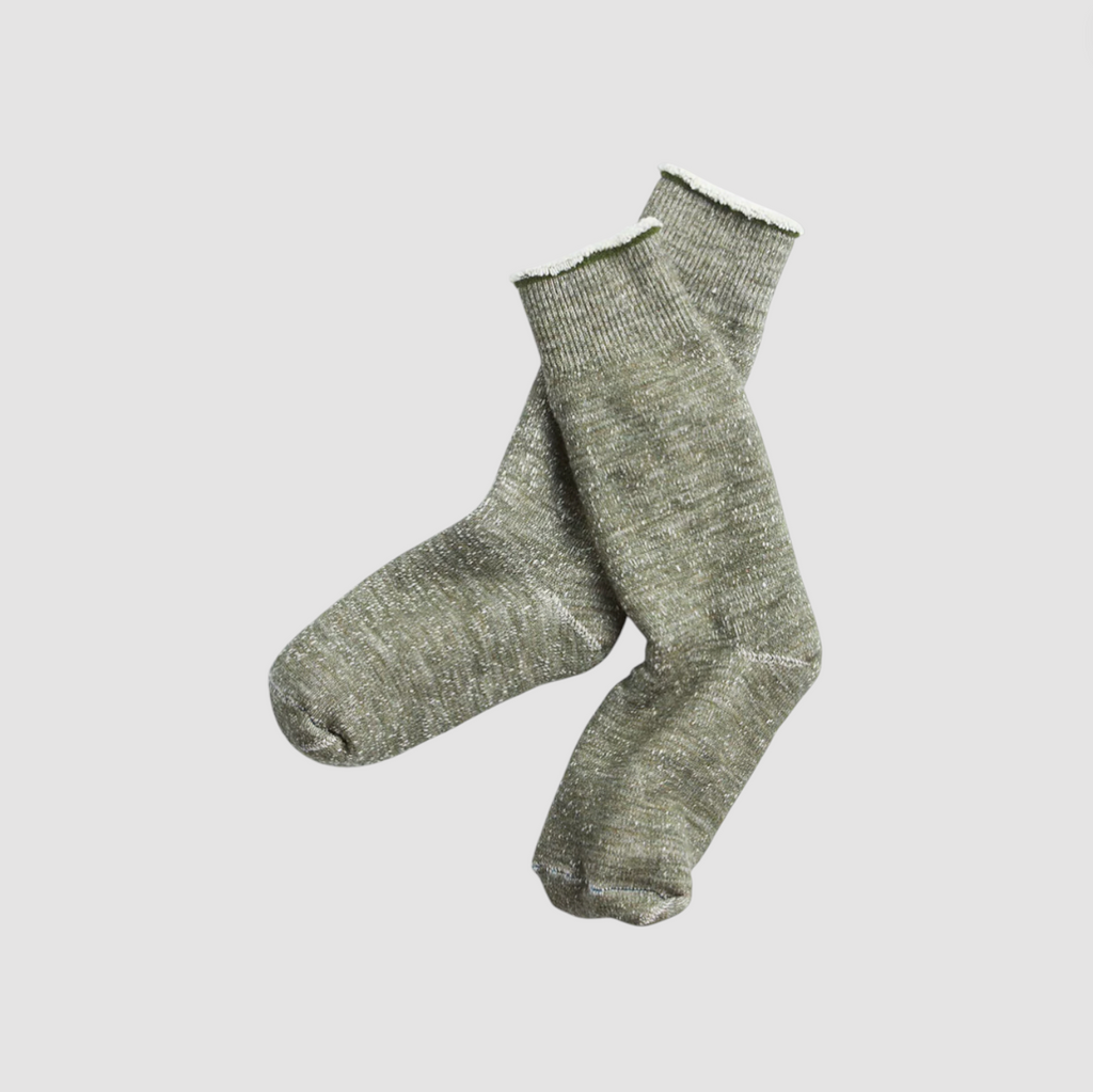Green cotton socks on a light grey background.