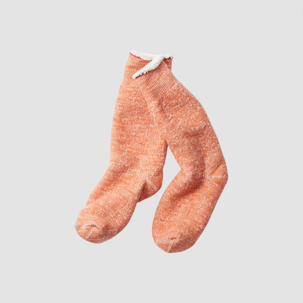 Orange socks on a light grey background.