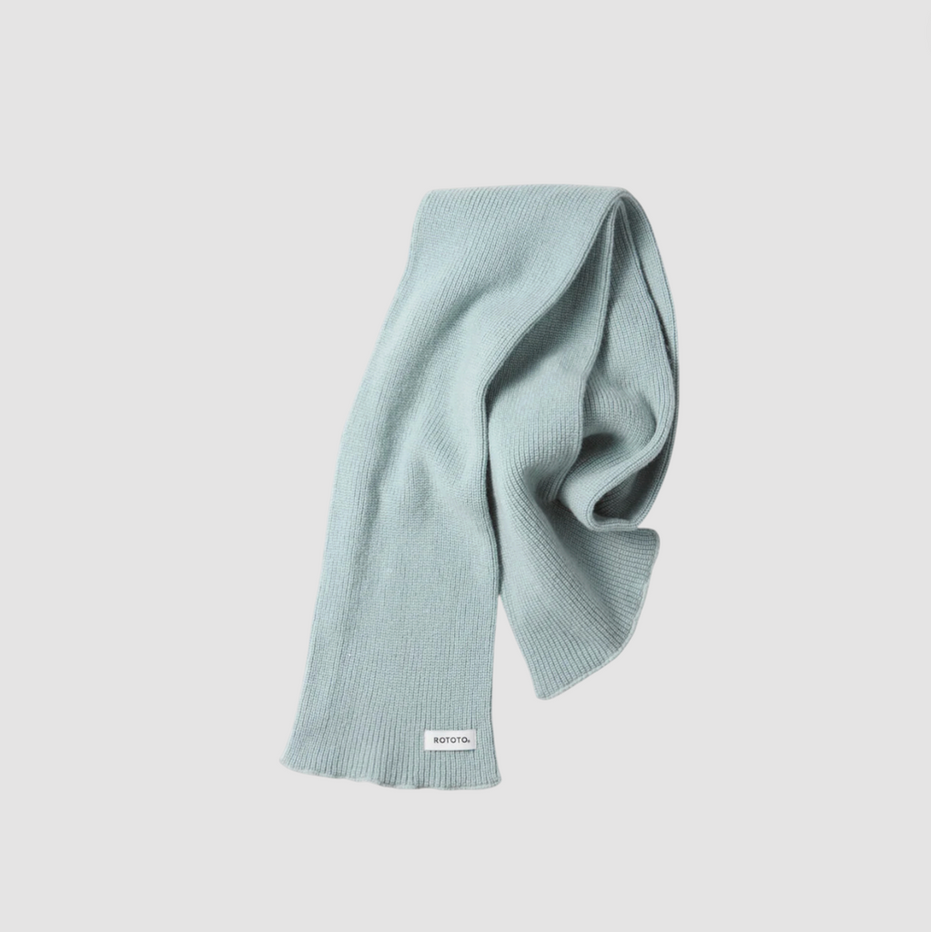 Light blue knitted scarf on a light gray background