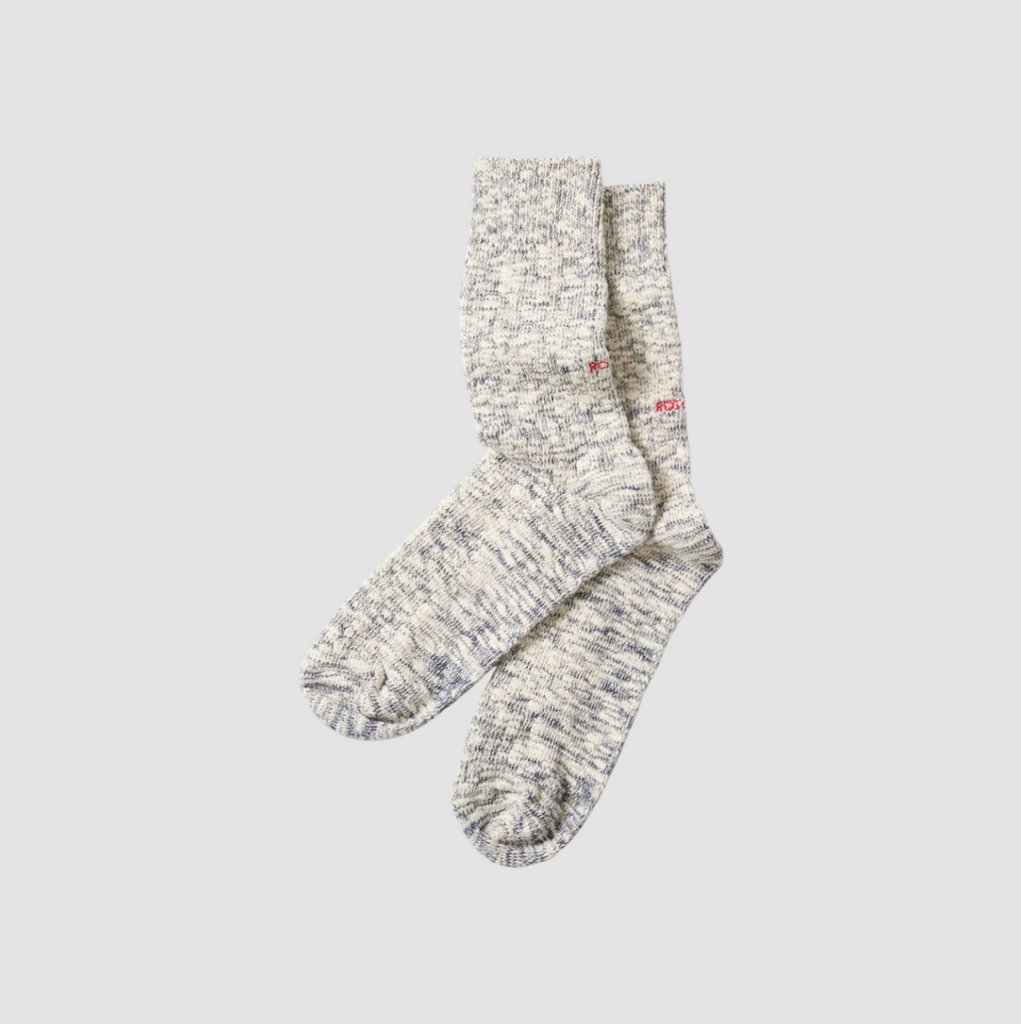 Blue and ecru cotton socks on a light grey background. 