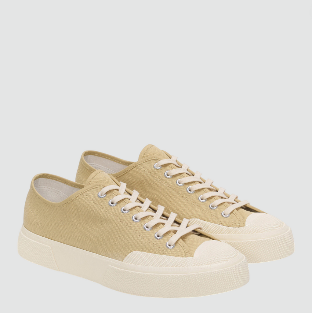 Beige low-top canvas sneaker with rubber toe cap, square toe, and vintage workwear-inspired details.