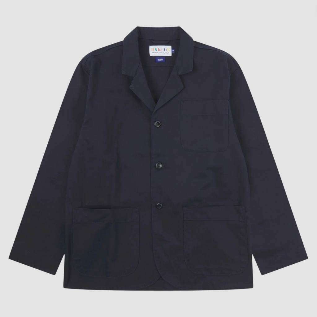 Navy blazer with button details on a light gray background.