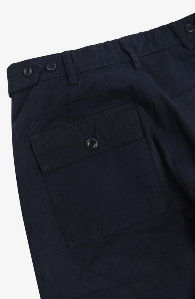 Close-up of dark blue pants with a pocket on a white background.