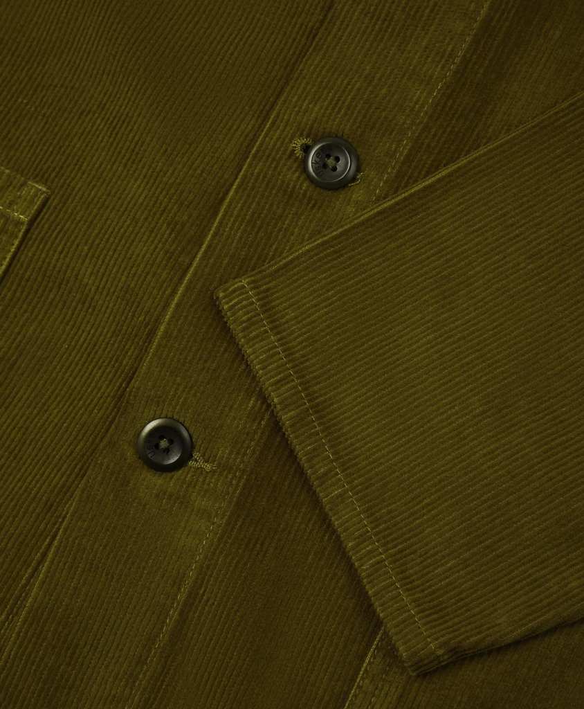 Close-up of a green corduroy jacket with buttons and fabric texture.