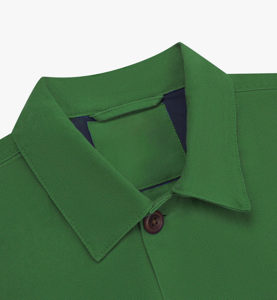 Mint green buttoned workshirt with a utilitarian fit, organic cotton fabric, chest pockets, reinforced elbows, and contrast-lined yoke and cuffs in dark blue.