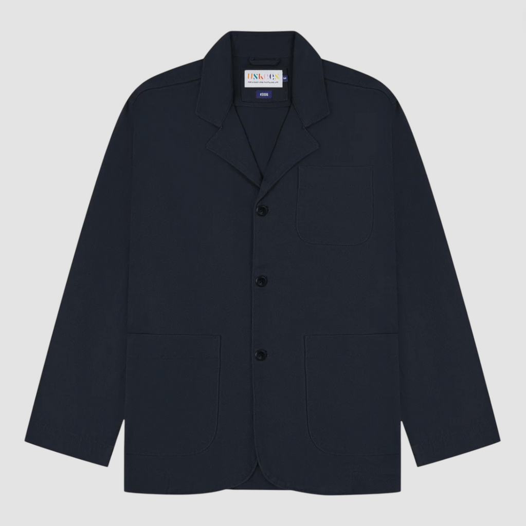 Navy blazer with button details on a light gray background.