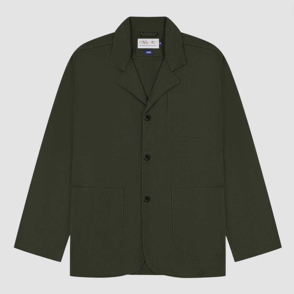 Green blazer with button details on a light gray background.