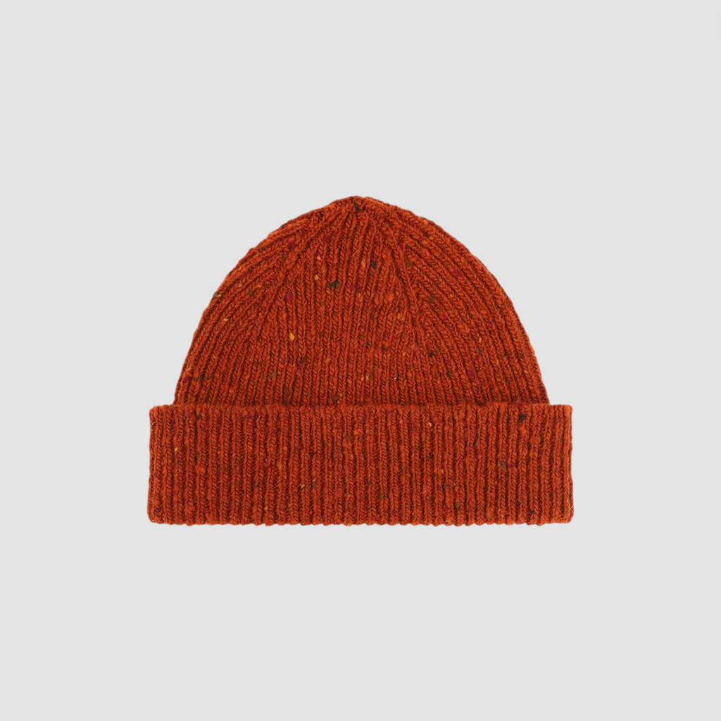 Orange knit beanie on a light gray background.
