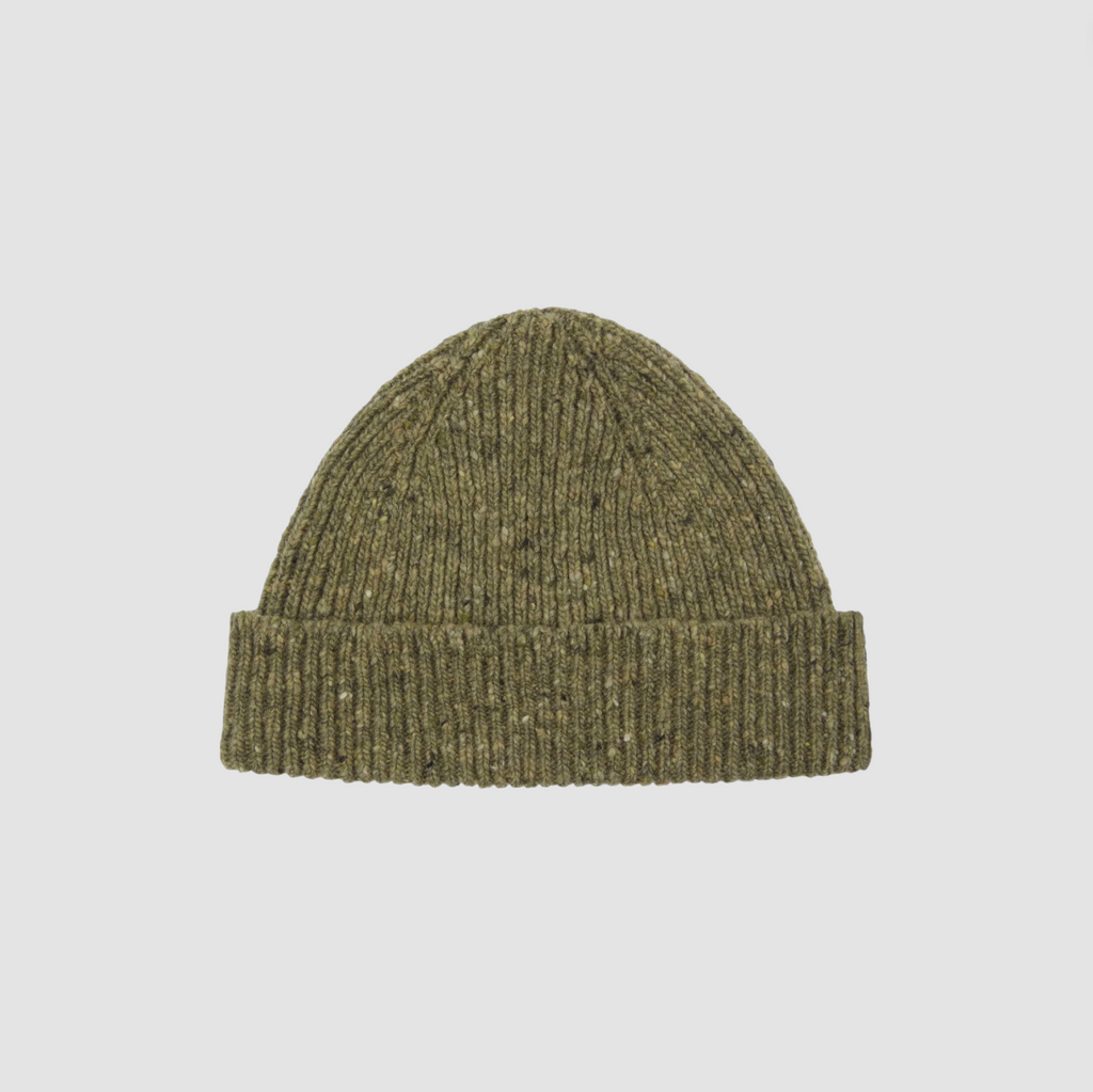 Green knit beanie on a light gray background.