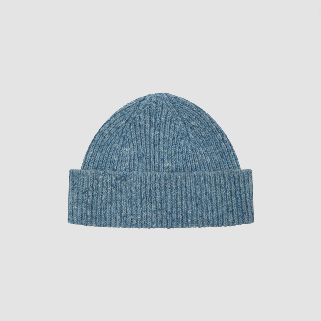 Blue knit beanie on a light gray background.