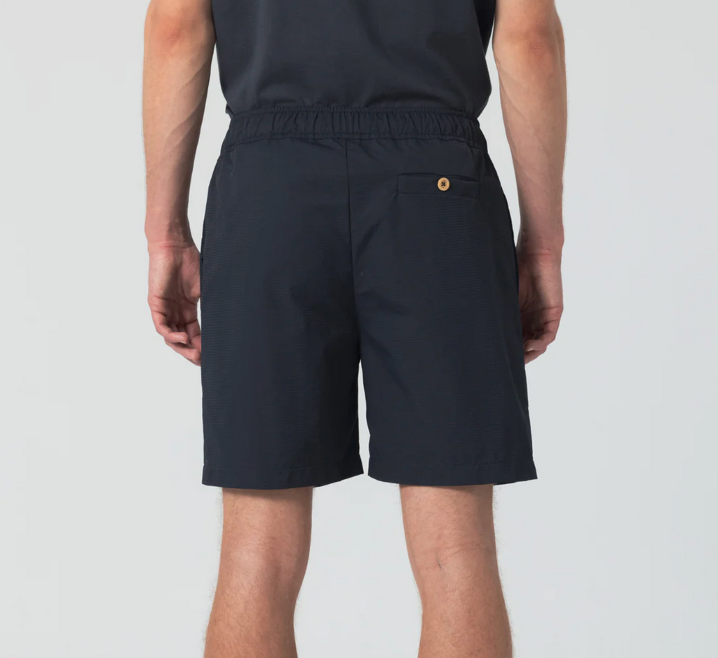 Dark navy sport shorts featuring wooden buttons, zipper closure, elastic waist, drawstring with metal aglets, and zippered side and back pockets.