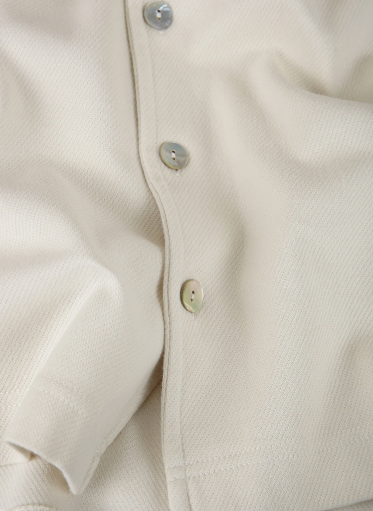 A lightweight polo shirt draped naturally, showcasing its breezy fit and premium stitching.