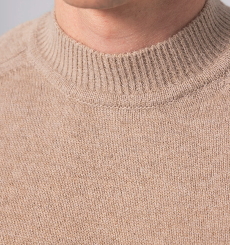 Beige turtleneck sweater crafted from a luxurious cashmere and merino wool blend, featuring raglan sleeves and ribbed hem and cuffs.