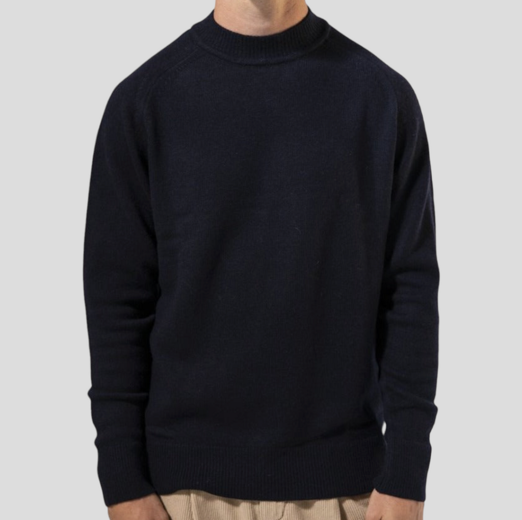 Warm navy knit sweater made in Portugal, showcasing a cashmere/merino mix with a turtleneck, raglan sleeves, and ribbed hem.