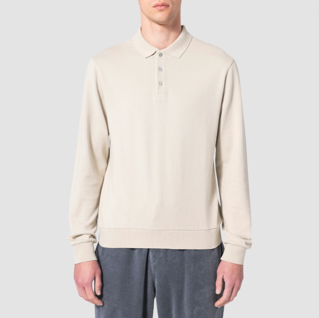 A long-sleeve polo in soft bone white, showcasing its premium organic cotton fabric.