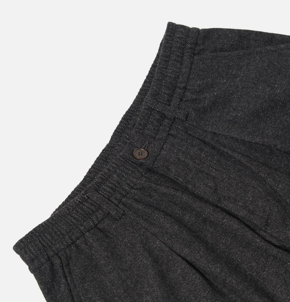 Dark gray pants with a button on a light gray background.