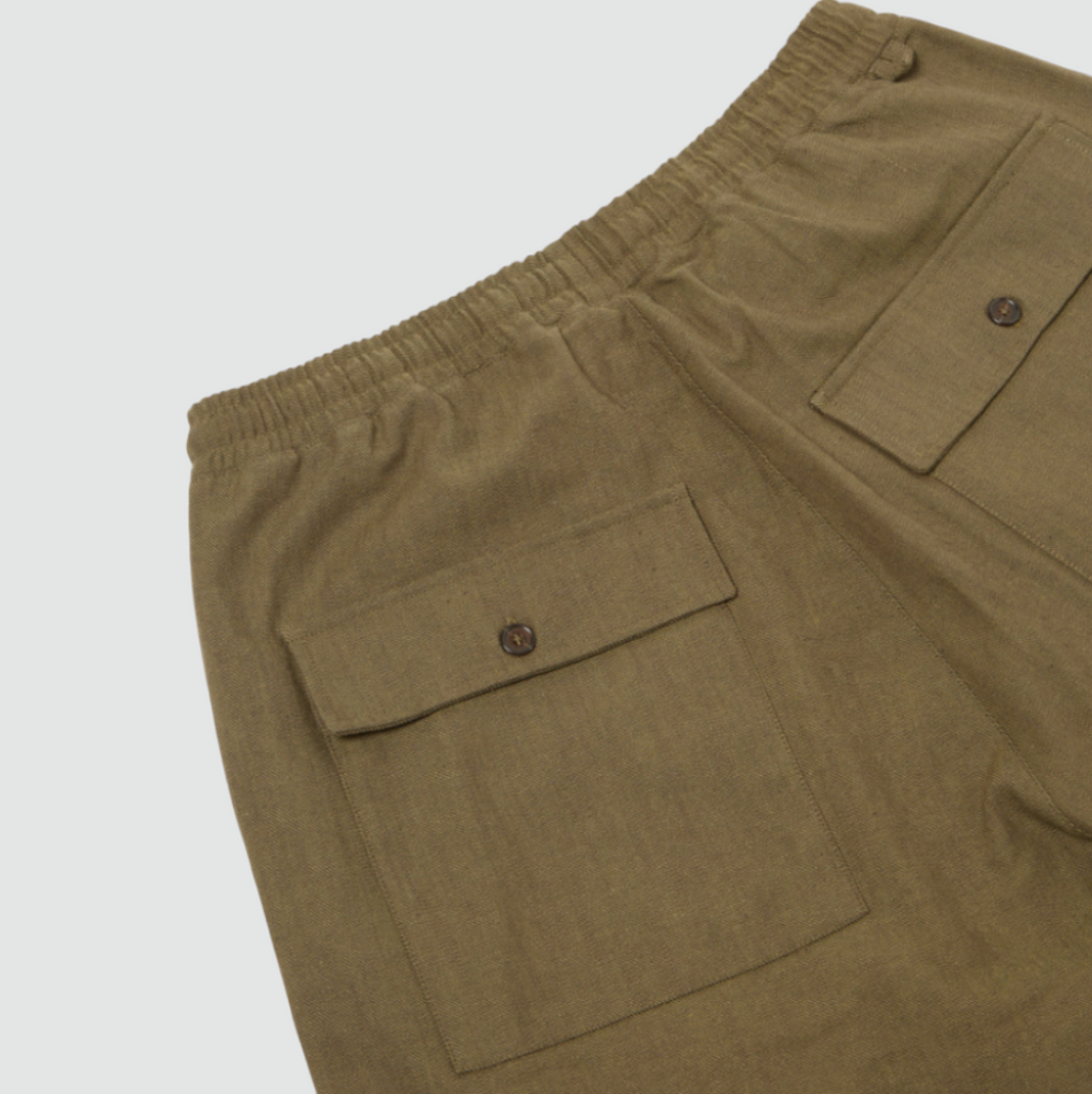 Olive green loose-fitting cotton pants with a drawstring waist, large front and back patch pockets, and wide hems. Made from durable twill weave fabric.