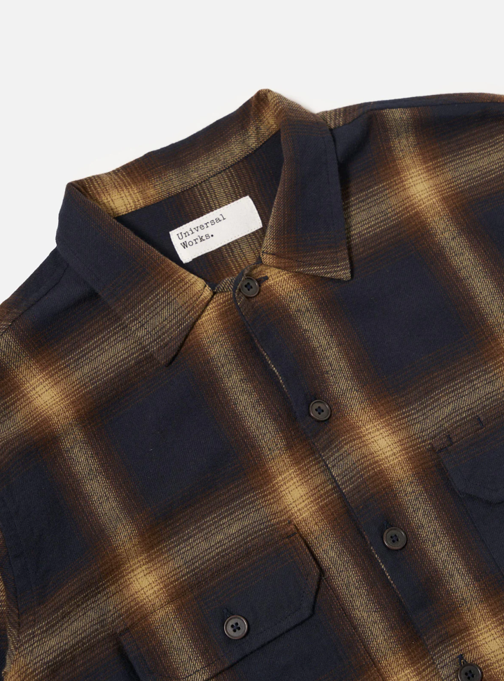 Close-up of a plaid shirt with a label on a white background.
