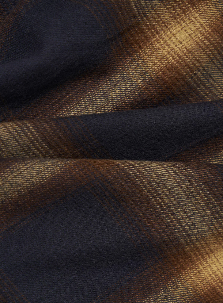 Close-up of plaid fabric with brown and navy pattern.