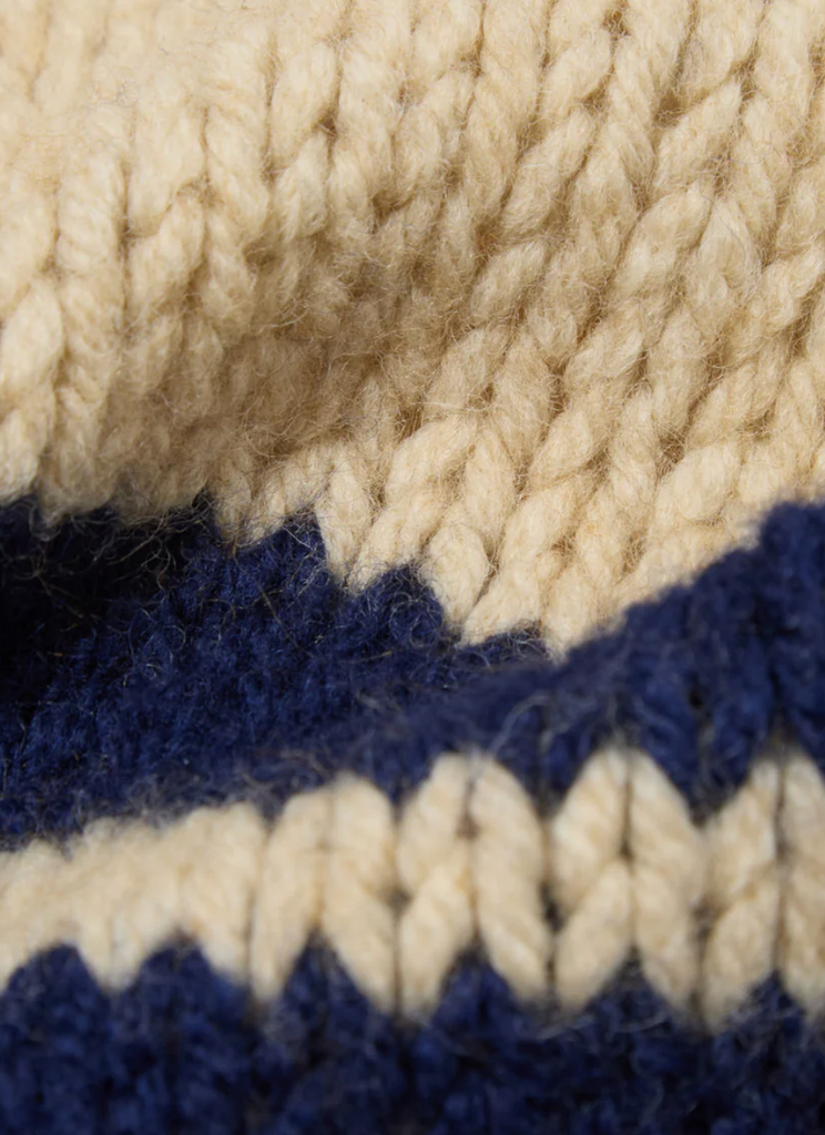 close up of beige and navy striped wool scarf. 