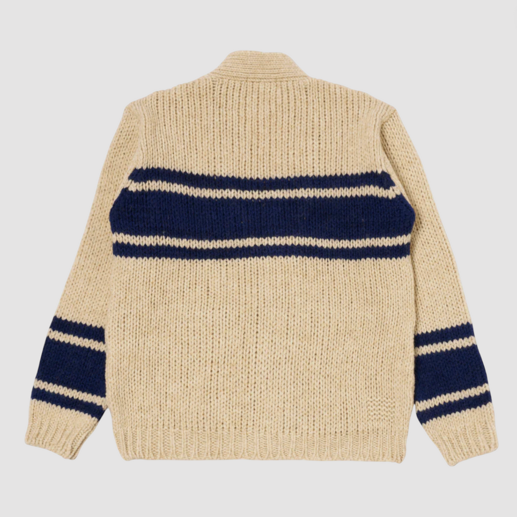 Beige and navy striped chunky knit wool cardigan on pale grey background.